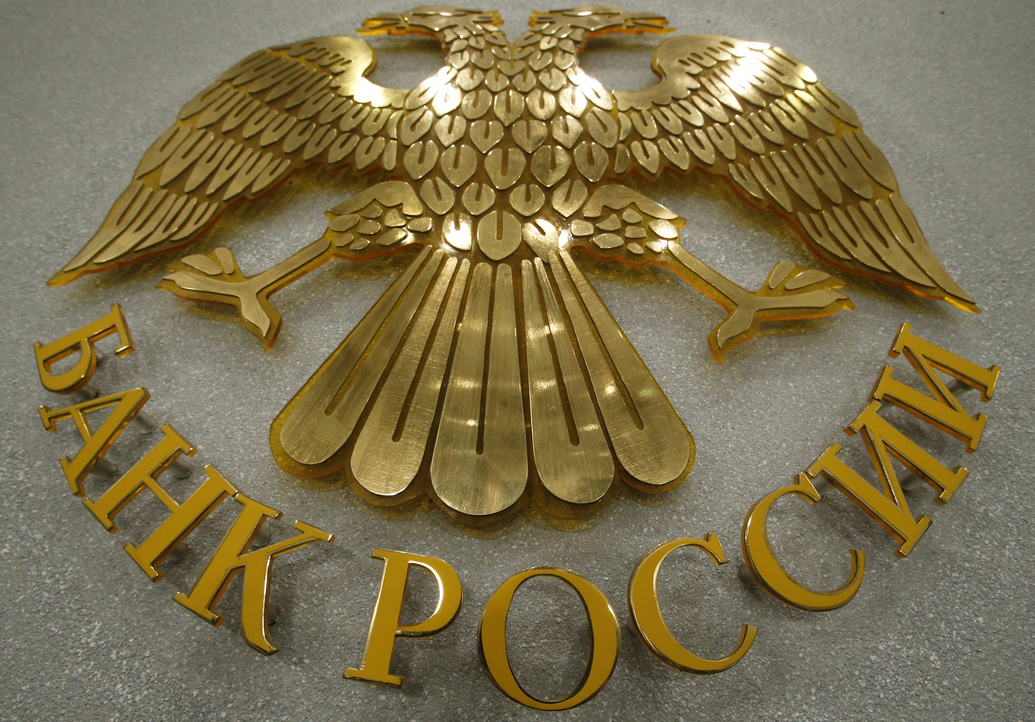A coat of arms of the Russia's Central Bank is pictured in the bank's press room in Moscow, March 13, 2015. The Russian central bank cut its main lending rate on March 13, for the second time this year, putting concerns about the declining economy before worries about high inflation. REUTERS/Sergei Karpukhin (RUSSIA - Tags: BUSINESS LOGO) - RTR4T8DC